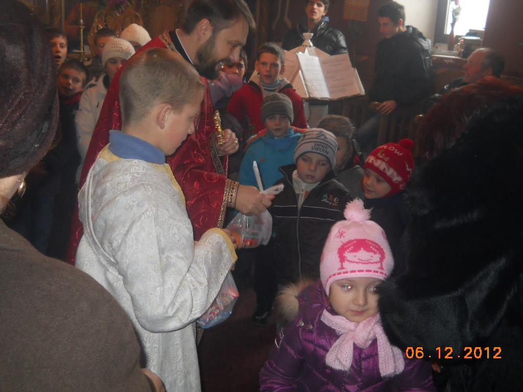 Copiii primesc cadouri de la parintele paroh